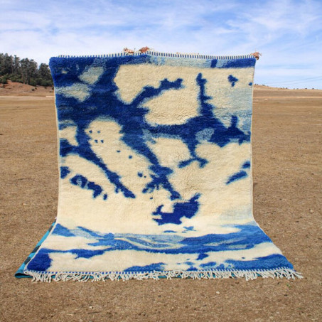 A handwoven Amazigh Moroccan rug, crafted by rural women, made from wool, and featuring a blend of blue and white colors to create intricate patterns