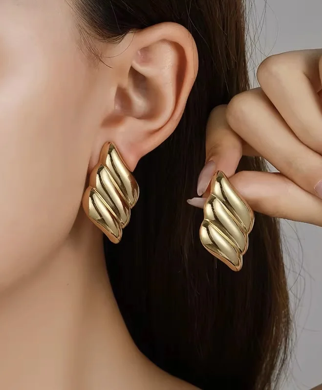 Boucles d’oreilles dorées en acier inoxydable au design moderne et élégant. Légères, résistantes et idéales pour un look chic au quotidien.