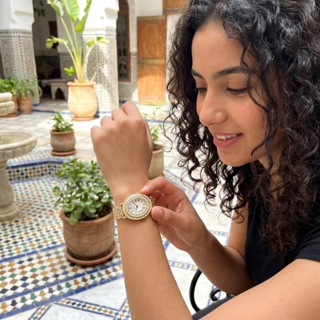 ساعة فاخرة — ذهبية بيضاوية مرصعة بالأحجار اللامعة