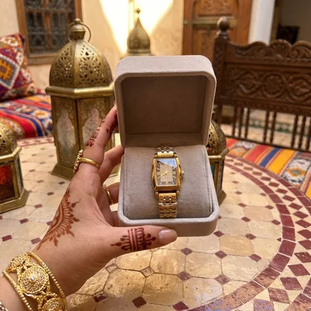 ساعة يد ذهبية فاخرة بوجه مستطيل مرصّع بالألماس