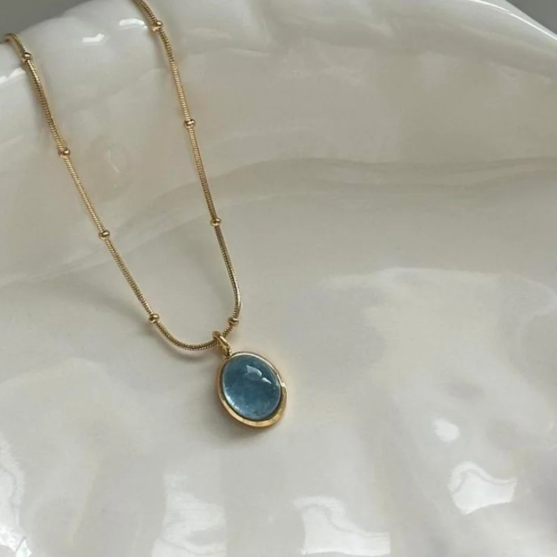 قلادة ذهبية بحجر دائري ملوّن – تصميم أنيق