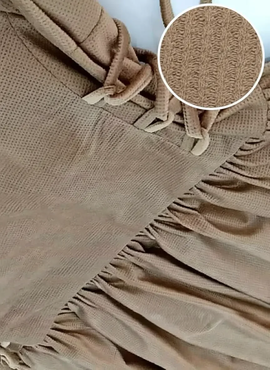 A close-up of brown, textured waffle-knit fabric.