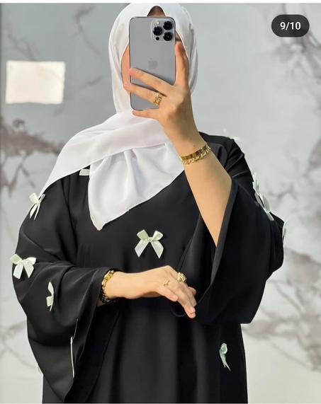 ✨عباية سوداء راقية مزينة بفيونكات أنيقة، تعكس جمال البساطة والفخامة في آنٍ واحد. الحجاب الأبيض يضفي لمسة من النقاء والتناسق، مما يجعل الإطلالة مثالية لكل من تبحث عن الأناقة المحتشمة بأسلوب عص
