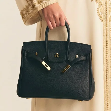 حقيبة هيرميس كيلي (Hermès Kelly) الجلدية الفاخرة باللون الأسود الملكي.