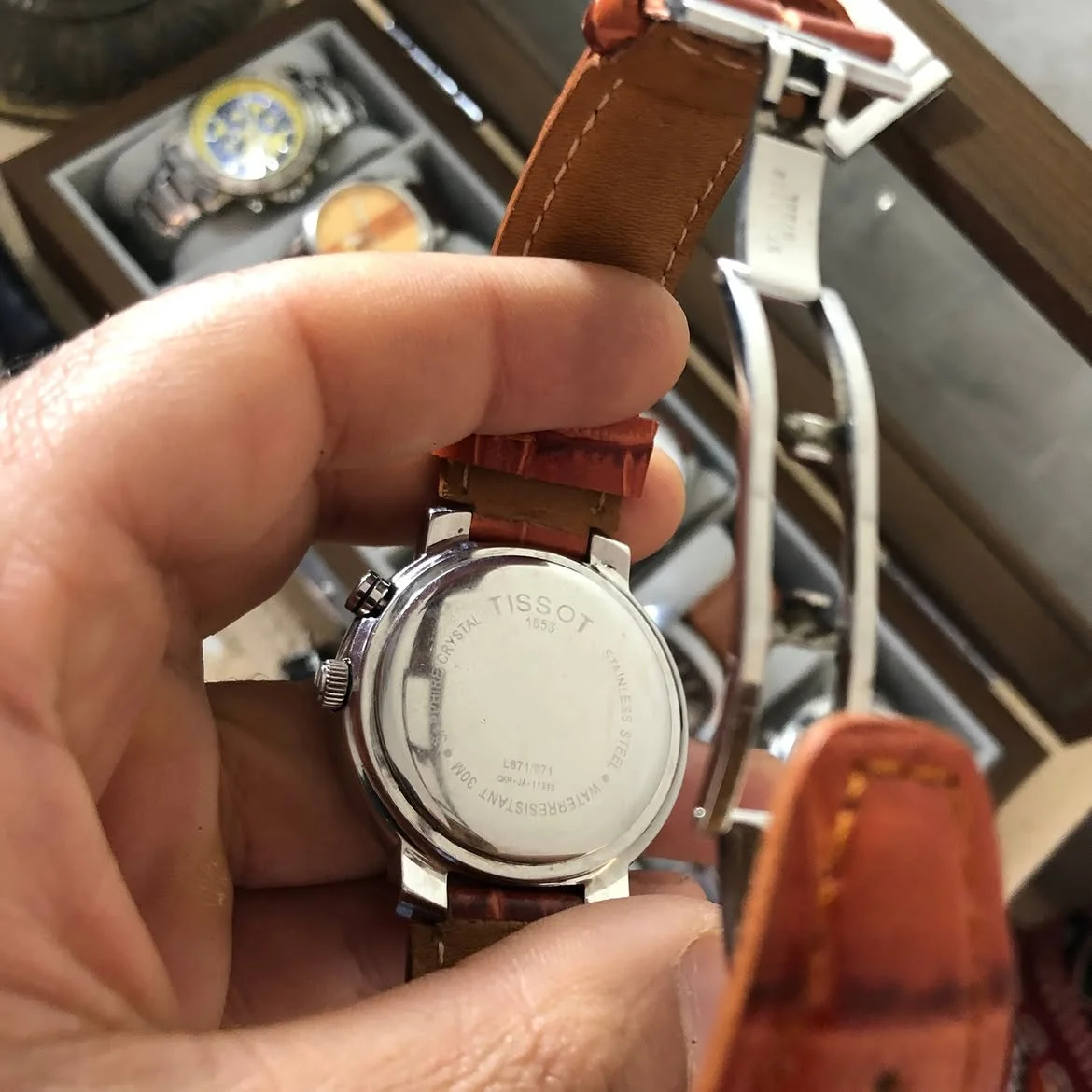 ⌚ montre au poignet est une Tissot Alarm Date (réf. T60.1.416.32 / L871/971) dotée d'un boîtier en acier inoxydable, d'un cadran blanc et d'un bracelet en cuir brun.