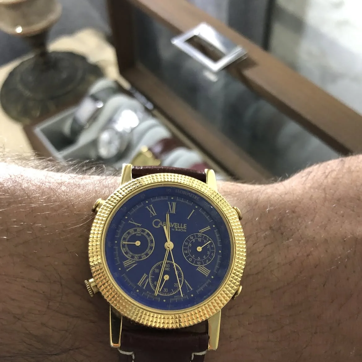 ⌚montre au poignet est un chronographe vintage Caravelle by Bulova doté d'un boîtier plaqué or à lunette cannelée et d'un cadran bleu vif avec index romains.