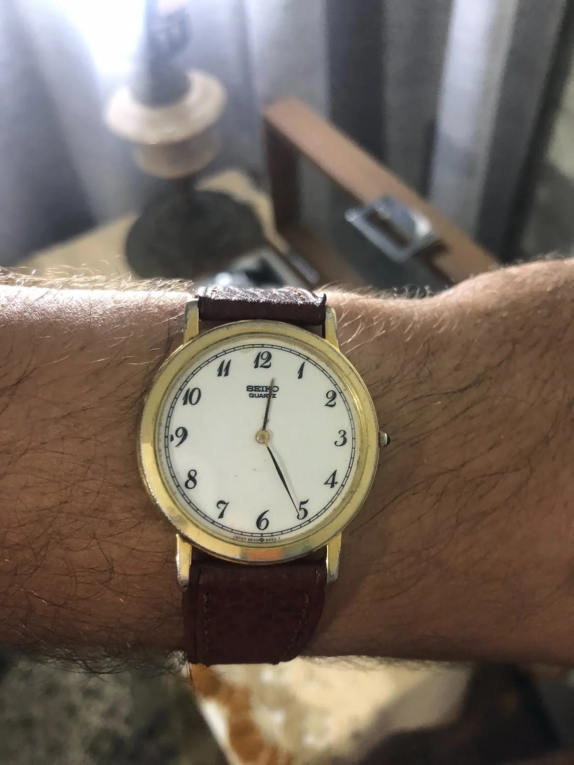 vintage Seiko Quartz ultra-thin dress watch. It features a classic round gold-plated case, an elegant white dial