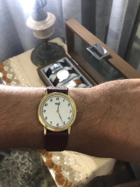 vintage Seiko Quartz ultra-thin dress watch. It features a classic round gold-plated case, an elegant white dial