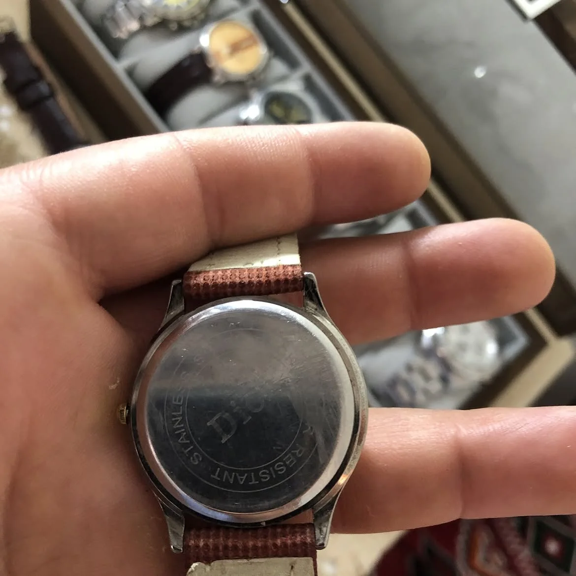 ⌚ Duward à mouvement quartz, dotée d'un cadran blanc avec des chiffres arabes dorés et d'un bracelet en cuir marron texturé.