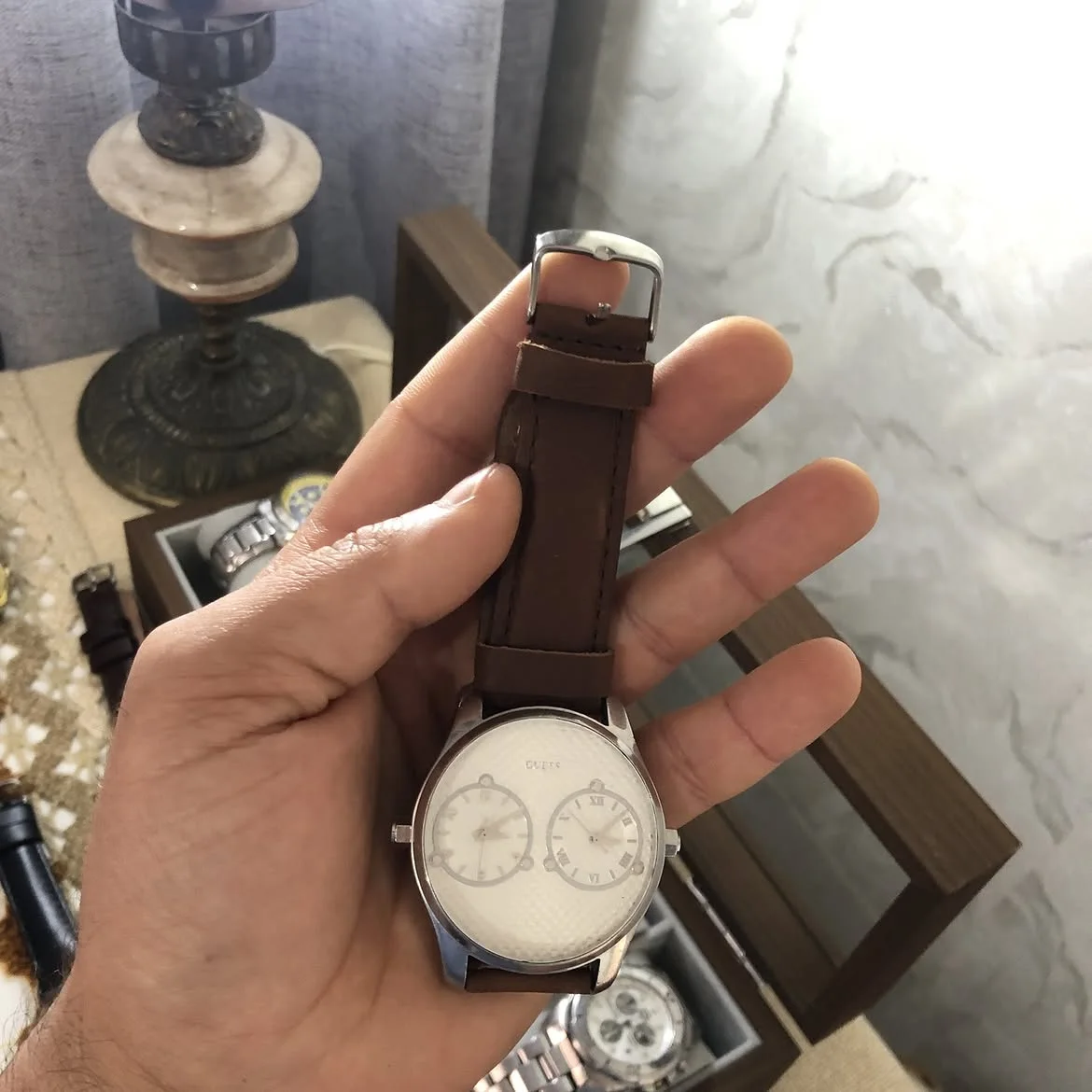⌚ montre Guess W80043G1 à double fuseau horaire se distingue par son boîtier en acier inoxydable et son bracelet en cuir marron.montre Guess W80043G1 à double fuseau horaire se distingue par