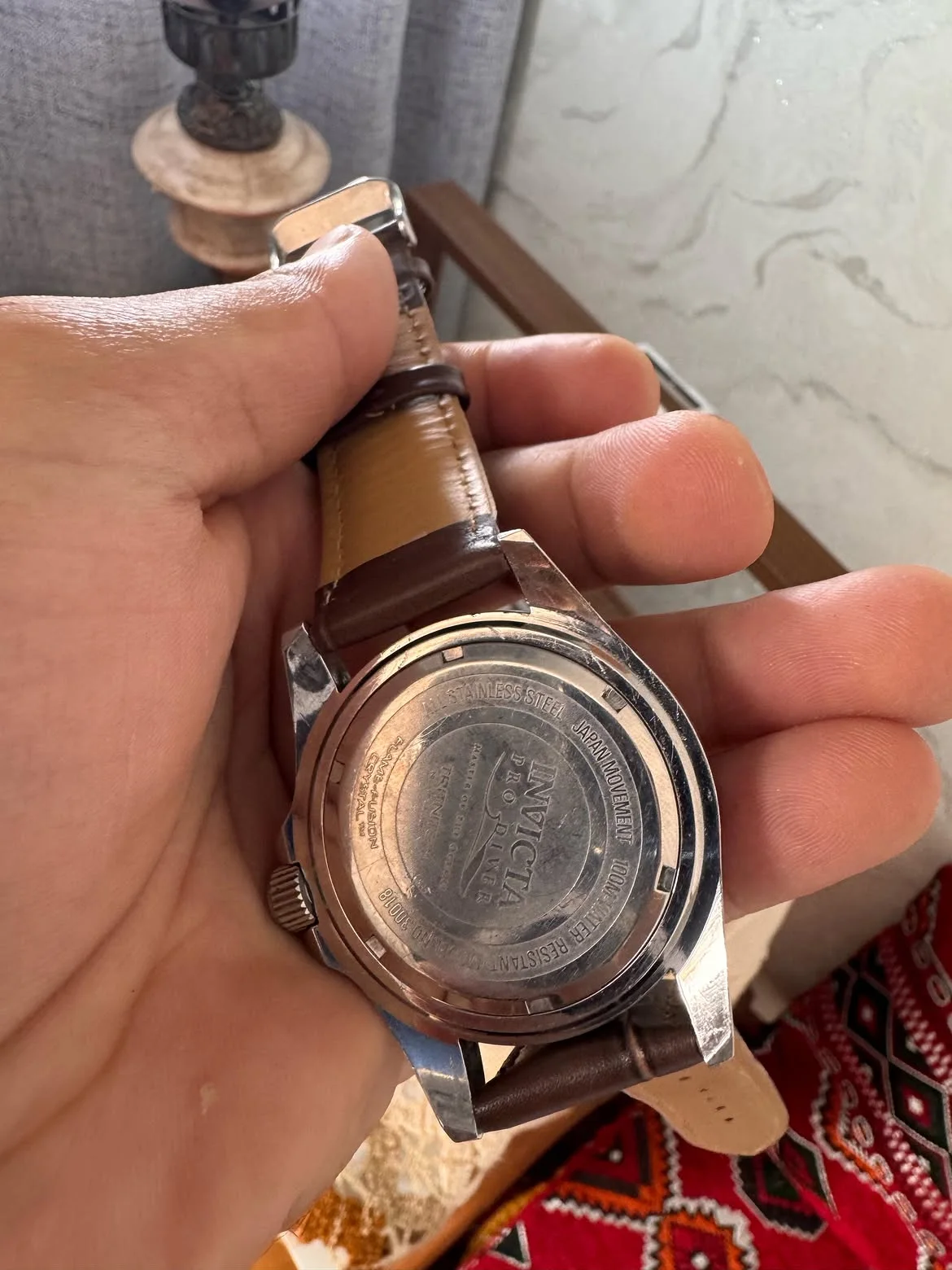 Cette montre au poignet est une Invicta Pro Diver (modèle similaire au 30018 ou 30806), dotée d'un boîtier en acier inoxydable, d'un cadran noir avec guichet de date et d'une lunette tournant