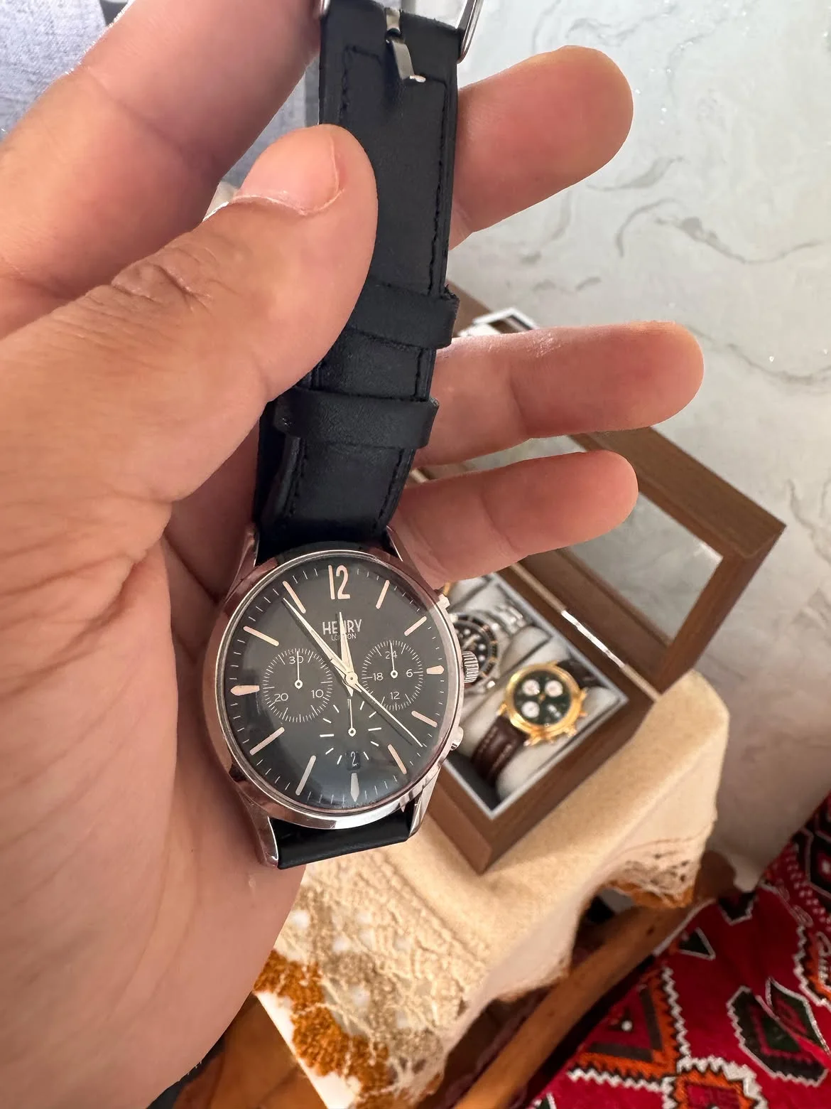 montre est une Henry London Edgware (modèle HL41-CS-0023) arborant un cadran noir et un bracelet en cuir noir.