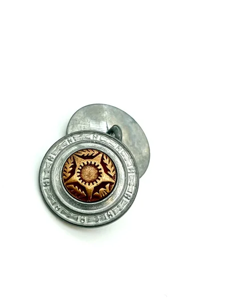 زر أكمام معدني دائري مع شكل نجمة مركزية.