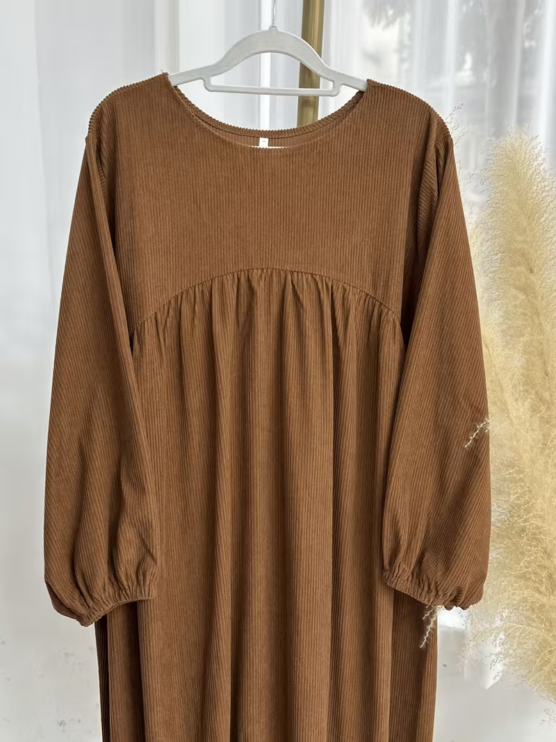 فستان طويل أنيق بقصّة فضفاضة وتفاصيل مطوية بتصميم فاخر