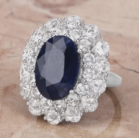 خاتم خطوبة بيضاوي مرصع بحجر ياقوت أزرق: فضة إسترليني عيار 925، مرصع بحجر توباز أبيض.