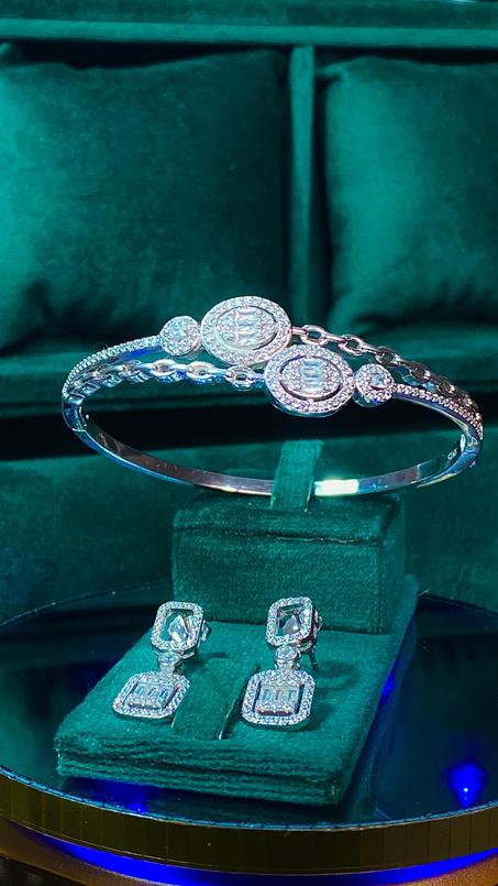 إكسسوارات فضية مرصعة بفصوص براقة تشمل سوارًا وأقراطًا بتصميم فاخر