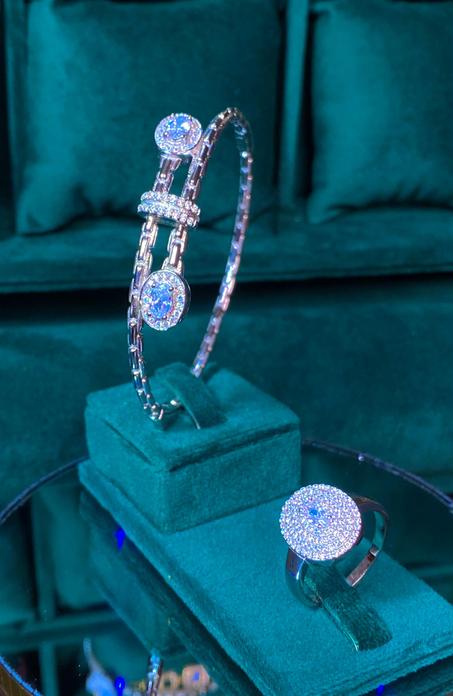 إكسسوارات فضية مرصعة بفصوص براقة تشمل سوارًا وأقراطًا بتصميم فاخر