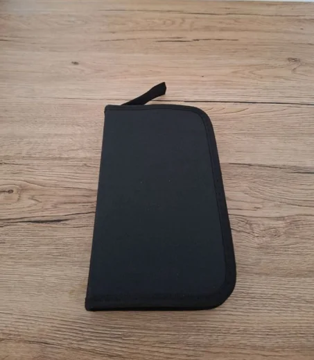 étui ou pochette de rangement noir(e), pliable, généralement en tissu ou en polypropylène