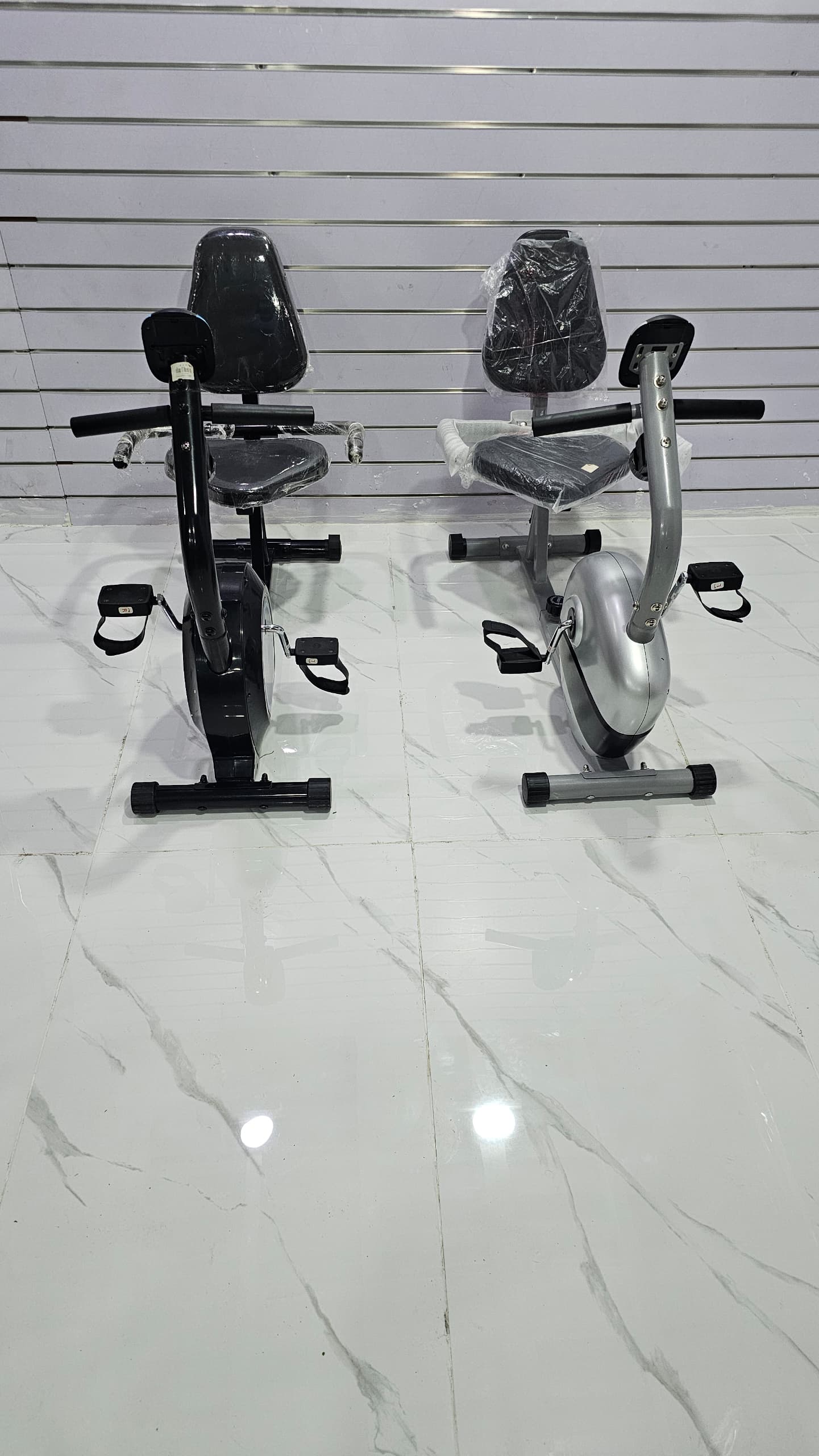 دراجة رياضية ثابتة (exercise bike)، وتحديداً من النوع الاستلقائي (recumbent bike) نظرًا لوضعية المقعد والظهر.
