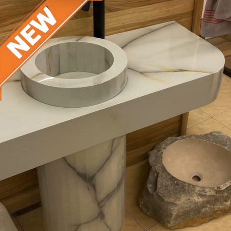 حمام عصري وفاخر يتميز بمغاسل مصنوعة من مواد حجرية وطبيعية.