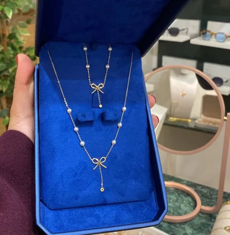 طقم عقد وأقراط أنيق مزين باللؤلؤ وتصميم عقدة رقيق.