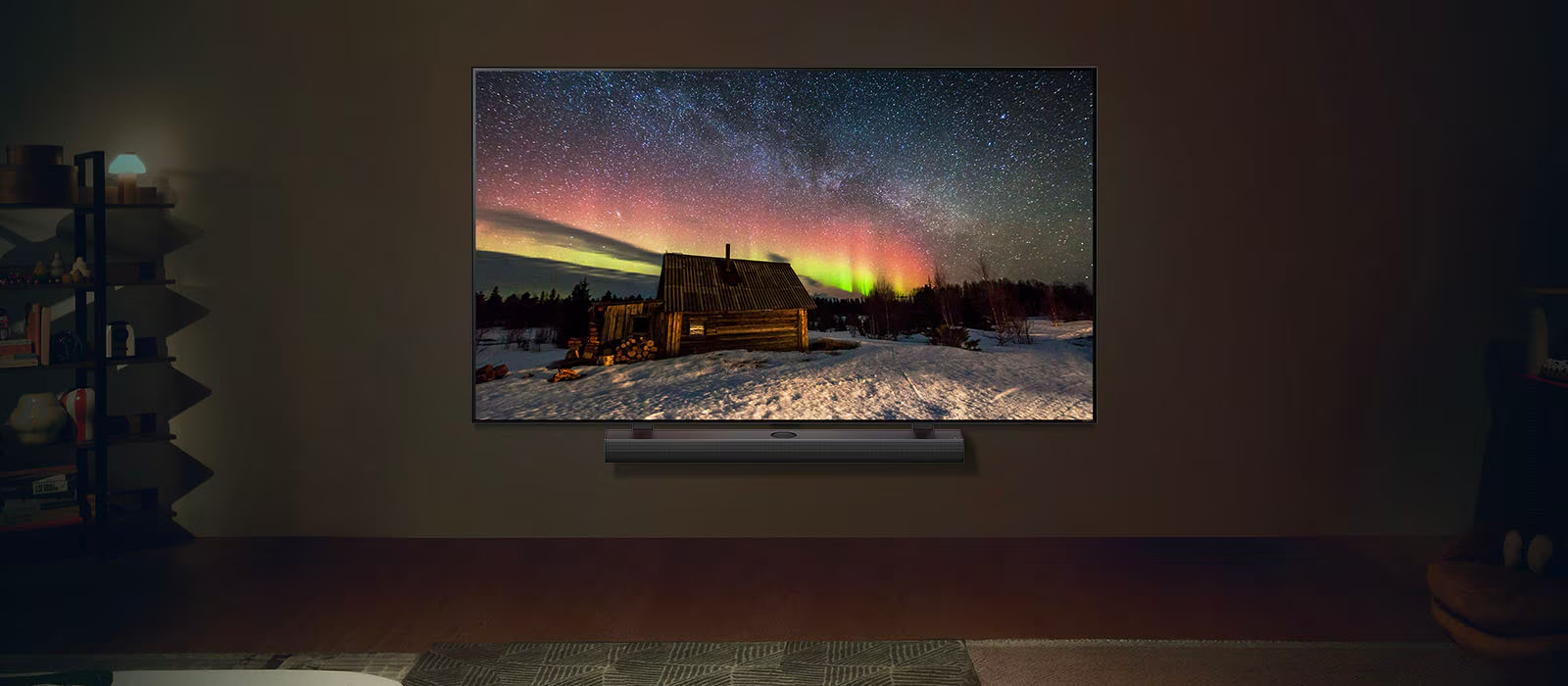 Téléviseur LG et barre de son LG dans un salon moderne, la nuit. L'image d'une aurore boréale est affichée à l'écran avec une luminosité idéale.