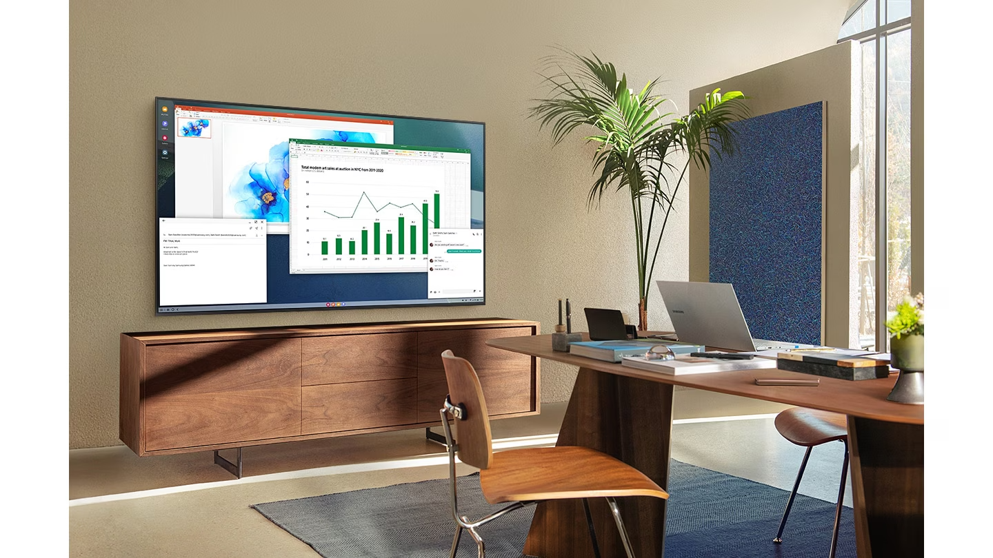 Dans un bureau à domicile dans un salon, un écran de télévision affiche la fonction PC sur TV qui permet au téléviseur domestique de se connecter au PC du bureau.