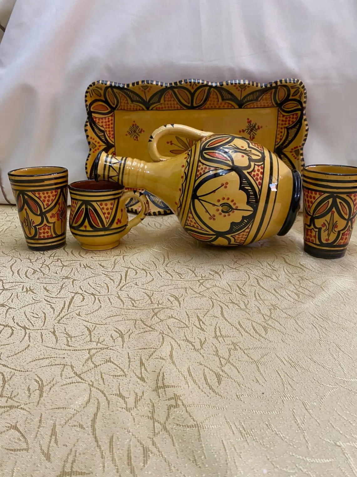 Un pot à eau avec des tasses en poterie,