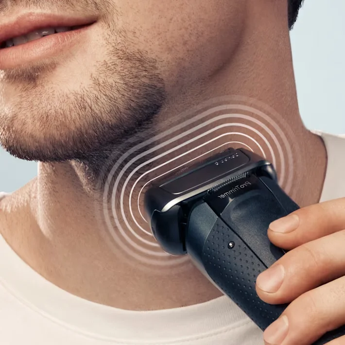 رجل يحلق رقبته بينما تظهر الذبذبات الصوتية حول رأس الماكينة رجل يحلق رقبته بينما تظهر الذبذبات الصوتية حول رأس الماكينة