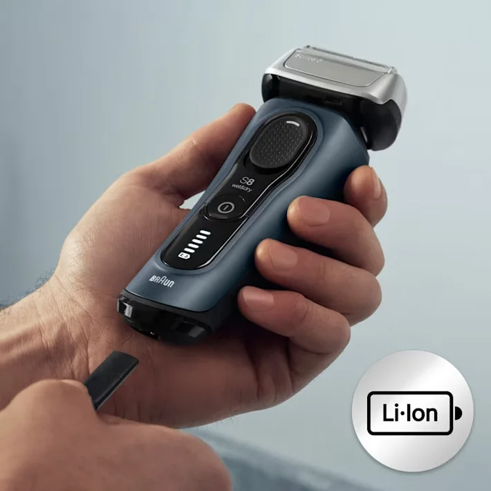 يد تحمل ماكينة الحلاقة فيما يتم وصل كابل الشحن بالمأخذ أسفل الماكينة يد تحمل ماكينة الحلاقة فيما يتم وصل كابل الشحن بالمأخذ أسفل الماكينة