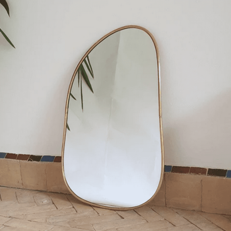 Miroir avec un cadre en cuivre doré.